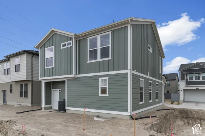 Two-story exterior featuring sage green vertical and horizontal lap siding, white trim detailing, and double-pane windows