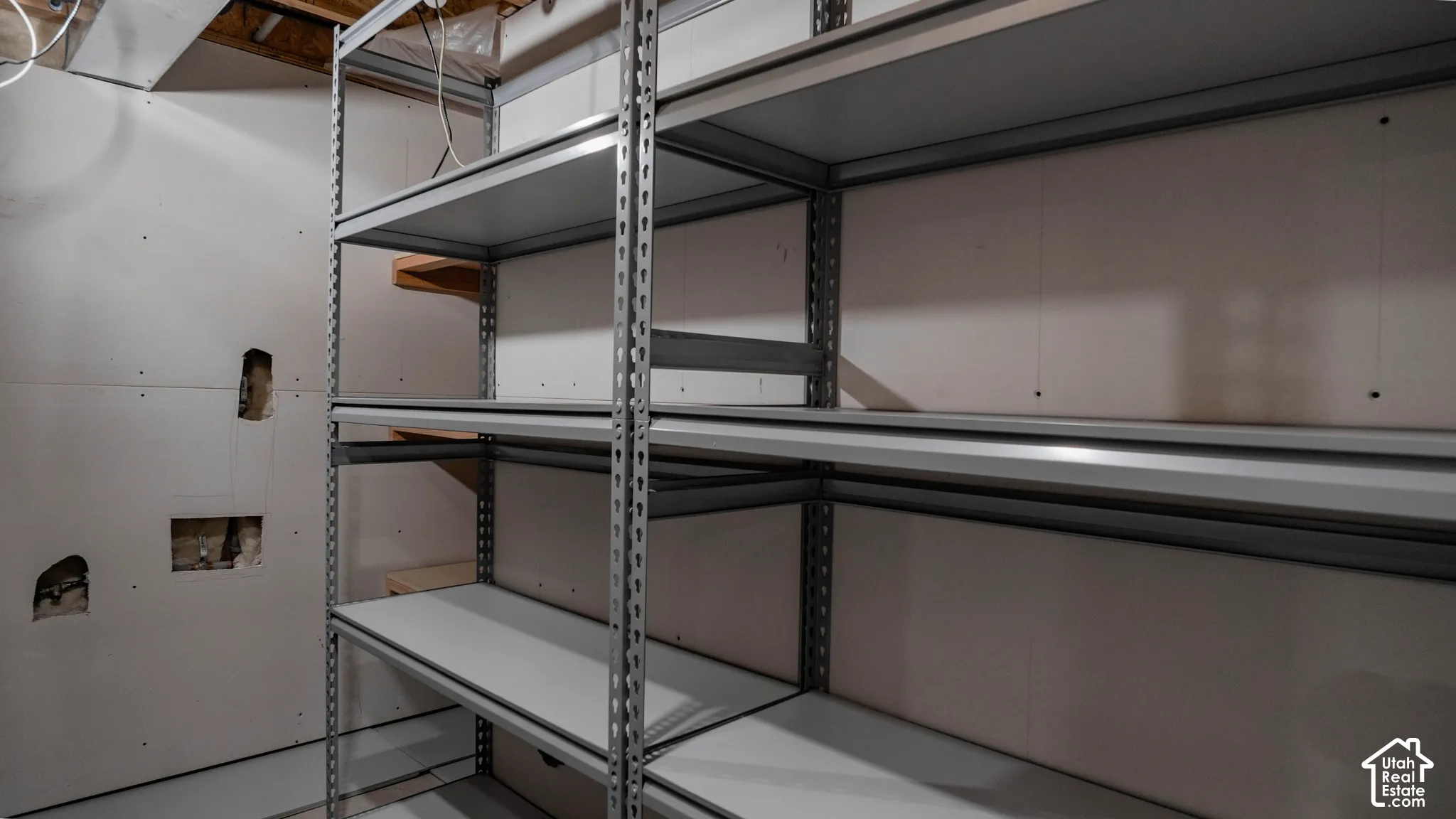 Storage area featuring industrial-grade metal shelving units and drywall partition walls