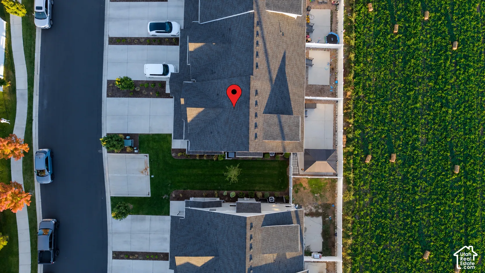 Aerial perspective featuring multi-unit building architecture with asphalt shingle roofing, private concrete driveway, and dedicated rear concrete patio space