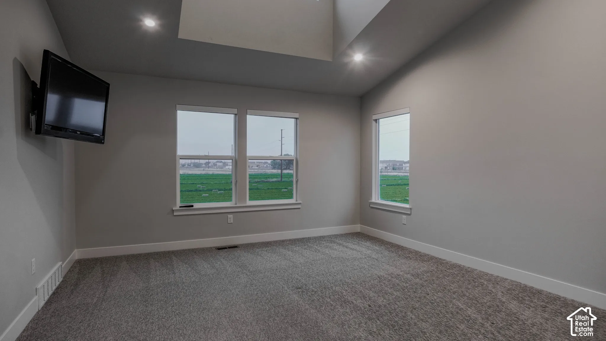 Vaulted ceiling featuring recessed lighting, neutral wall paint, and windows with multi-pane glazing