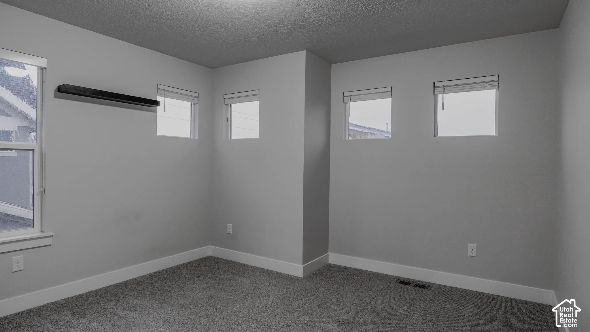 Neutral-toned room featuring high-set windows, wall-to-wall carpeting