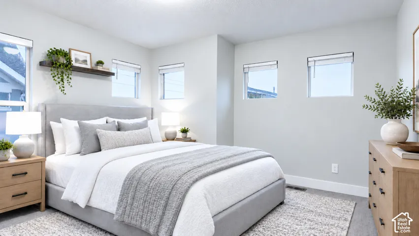 Neutral-toned bedroom featuring multiple square windows, wall-to-wall carpeting
