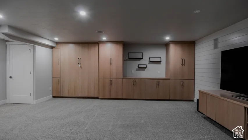 Custom floor-to-ceiling cabinetry, shiplap wall accent, recessed lighting, and wall-to-wall carpeting
