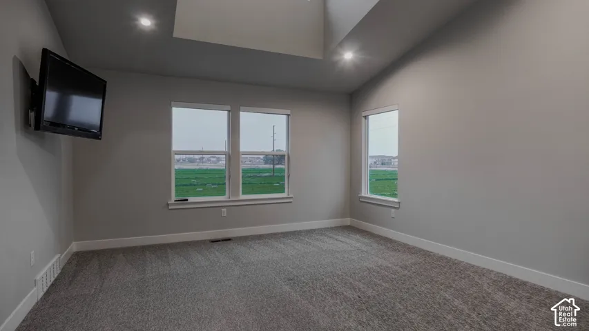 Vaulted ceiling featuring recessed lighting, neutral wall paint, and windows with multi-pane glazing