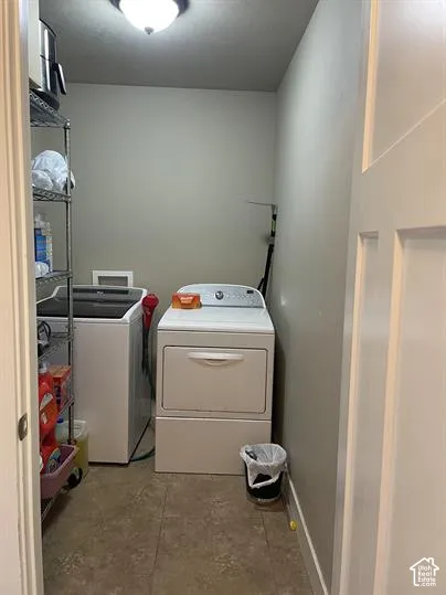 Laundry area featuring neutral-toned walls, tile flooring, and a ceiling-mounted light fixture