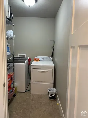 Laundry area featuring neutral-toned walls, tile flooring, and a ceiling-mounted light fixture