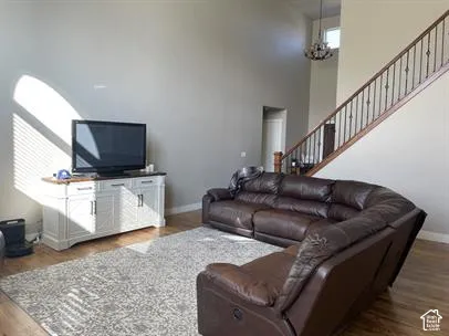 Expansive vaulted ceilings, wood-finish flooring, and a staircase with decorative metal balusters