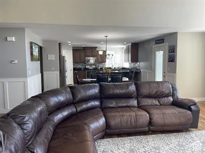 Interior featuring wood-finish cabinetry, decorative wainscoting, recessed lighting, and a multi-light chandelier
