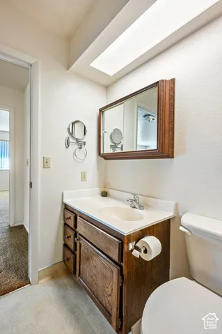 Built-in wood cabinetry vanity with integrated countertop, inset sink, chrome faucet, and matching framed medicine cabinet under a recessed soffit light