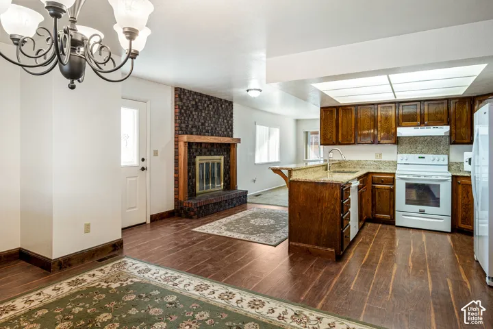 Kitchen featuring wood-finish cabinetry, stone countertops, a peninsula, and recessed lighting