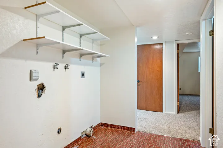 Utility space featuring wall-mounted adjustable shelving, recessed lighting, and tile flooring