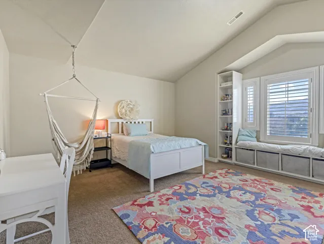 Vaulted ceiling, built-in floor-to-ceiling shelving, custom window seat with integrated storage, and plantation shutters