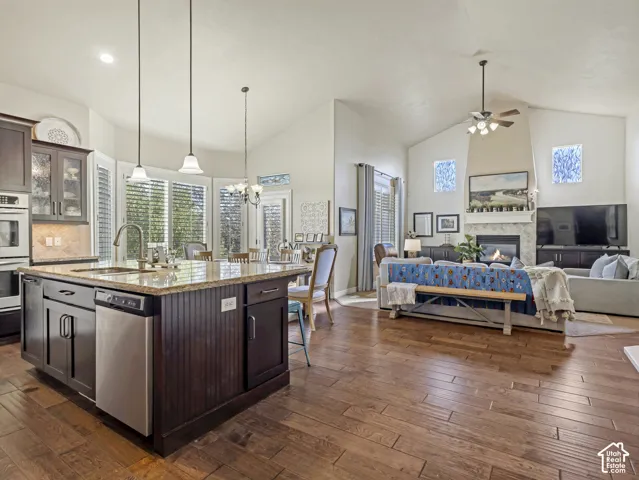 Kitchen featuring a center island with stone-style countertops, stainless steel appliances, and dark cabinetry