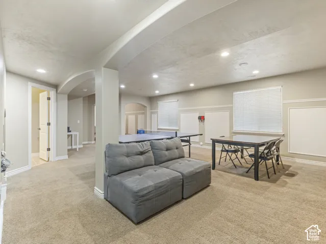 Neutral-toned interior featuring wall molding, arched architectural detailing, recessed lighting, and wall-to-wall carpeting