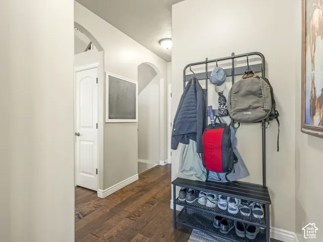 Entryway featuring wood-finish flooring, arched architectural openings, and a solid-core paneled door