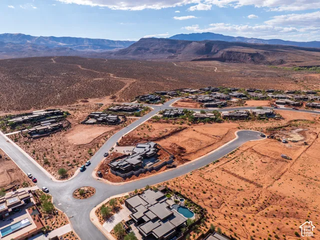 Aerial view of a residential development with paved roads and a central roundabout