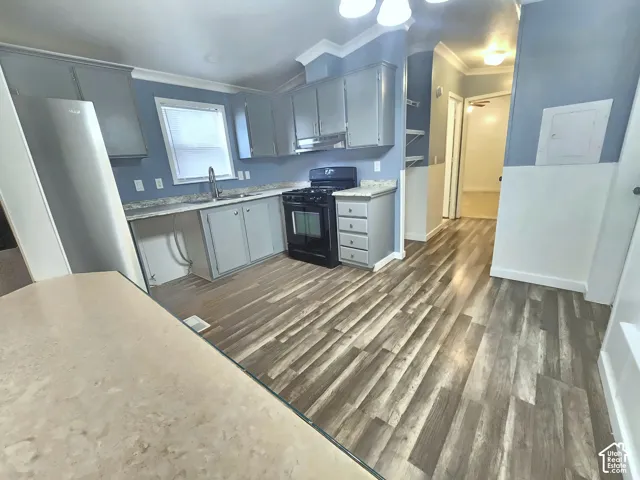 Kitchen featuring grey cabinetry, wood-finish flooring, stone-finish countertops, and a built-in range