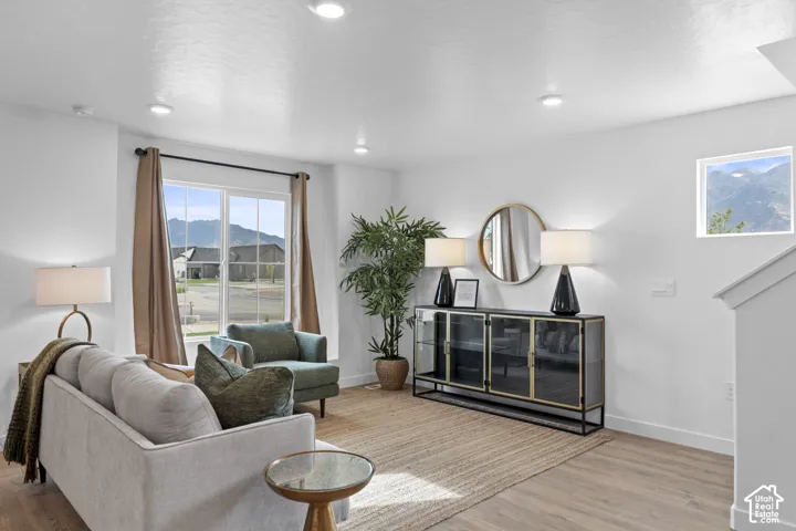 Living area featuring wood-finish flooring, recessed lighting, and large windows with mountain scenery