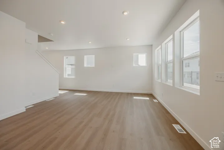 Open interior space featuring wood-finish flooring, recessed lighting, and multiple paneled windows