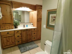 Custom built-in wood cabinetry with integrated lighting and hardware, solid surface countertop, inset sink, and tile flooring