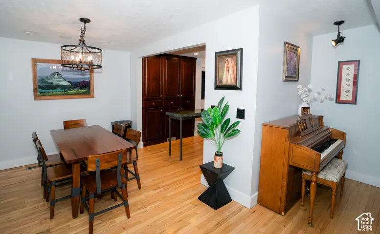 Hardwood flooring, custom dark-stained built-in cabinetry, decorative drum pendant lighting, and directional ceiling spotlighting