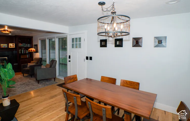 Drum-style chandelier featuring rope detailing and a matte black finish, wood-finish flooring, and white multi-pane entry door