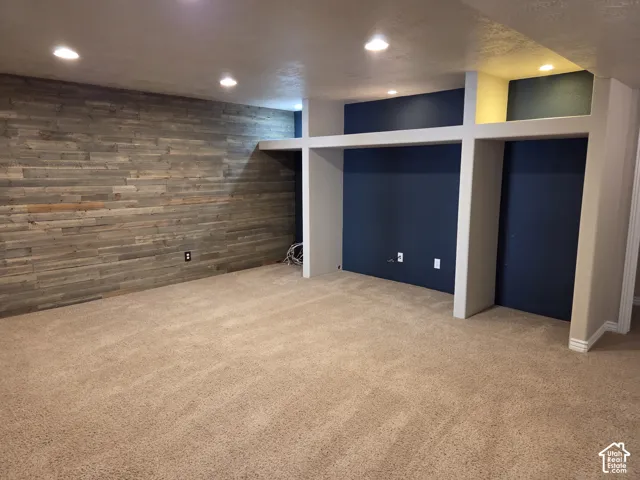 Recessed lighting, wood-plank accent wall, and built-in shelving with integrated wall niches