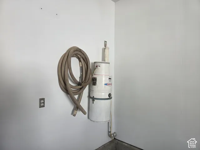 Wall-mounted central vacuum system featuring a canister unit and integrated storage hose