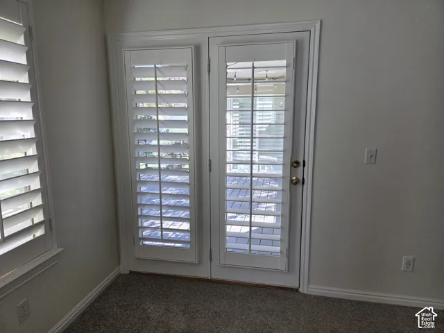 Full-lite glass French doors with integrated white plantation shutters