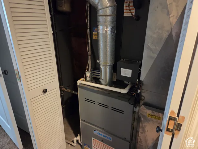 Daikin HVAC furnace unit featuring metal ductwork and louvered closet doors