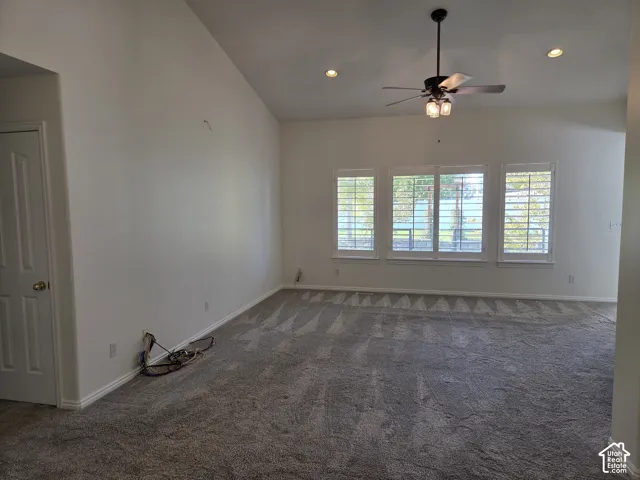 Vaulted ceilings, three windows with interior plantation shutters, recessed lighting, and a ceiling fan with integrated light fixture