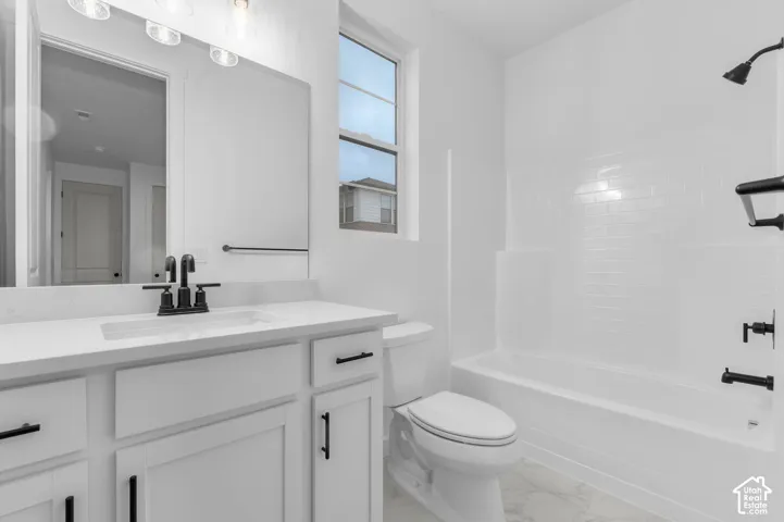 White vanity with a stone countertop, undermount sink, and matte black faucet, featuring a tub-and-shower combination with subway-style tile surround and matte black fixtures