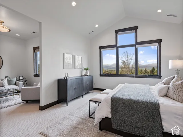 Vaulted ceiling featuring recessed lighting, expansive multi-pane windows with dark trim, and mountain scenery