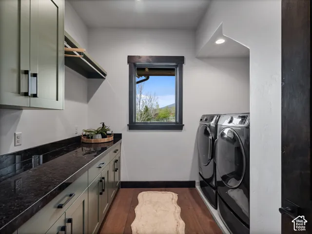 Built-in cabinetry with dark stone countertops, wood-finish flooring, dark wood window trim, and overhead recessed lighting