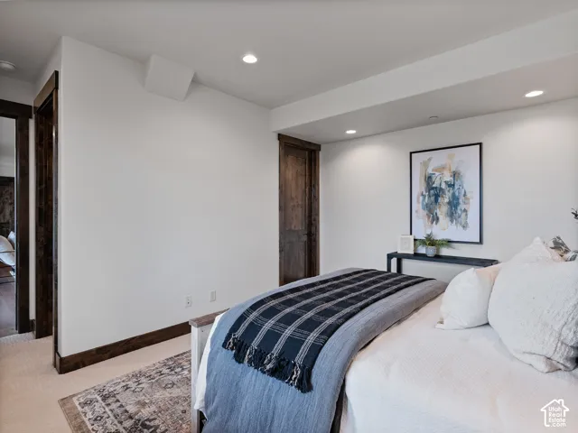 Neutral wall finishes featuring dark-stained wood door casing and matching interior doors, complemented by recessed ceiling lighting