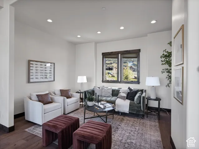 Living area featuring wood-finish flooring, recessed lighting, and dark-toned window trim