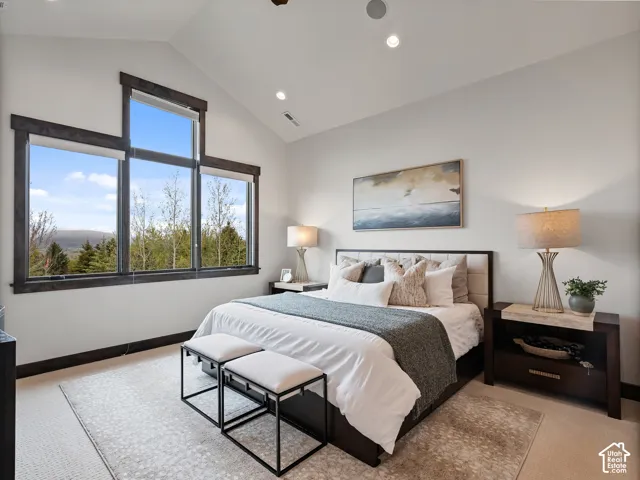 Vaulted ceiling with recessed lighting, oversized windows with dark wood-finish trim, and neutral wall-to-wall carpeting