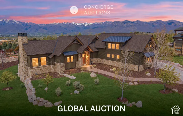 Craftsman-style residence featuring horizontal siding, natural stone veneer, a metal roof accent, an exterior stone chimney, and mountain scenery