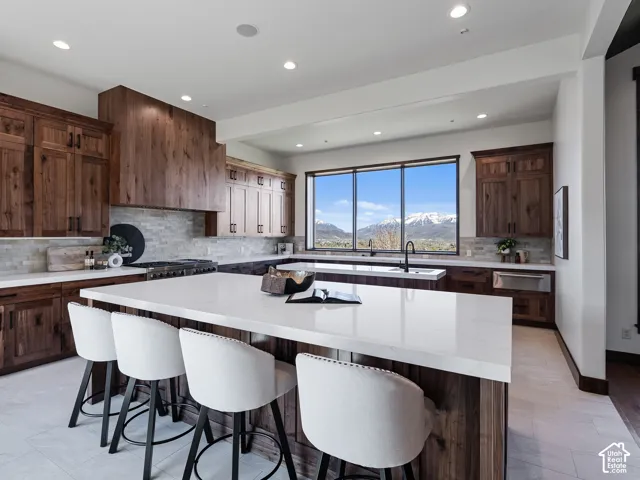 Kitchen featuring dark wood cabinetry, quartz countertops, dual islands, recessed lighting, and a large window with mountain scenery