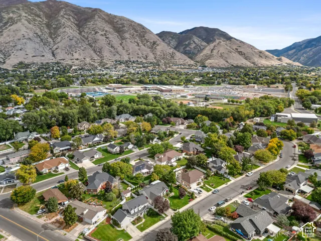 Aerial perspective of a suburban neighborhood framed by prominent mountain ranges and mature tree-lined streets