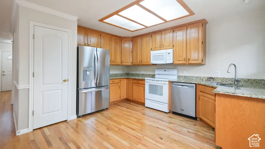Kitchen featuring wood cabinetry, stone countertops, stainless steel appliances, recessed ceiling lighting, and wood-finish flooring