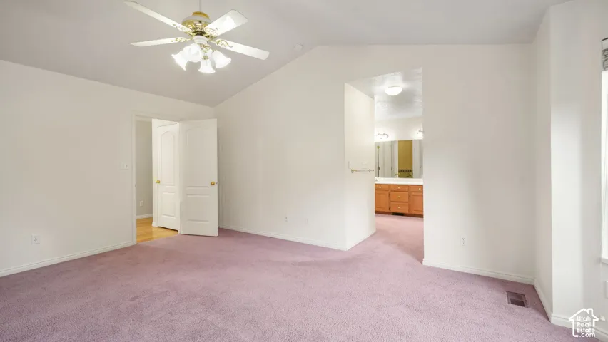 Vaulted ceilings, carpeting, ceiling-mounted light fixture, and paneled doors