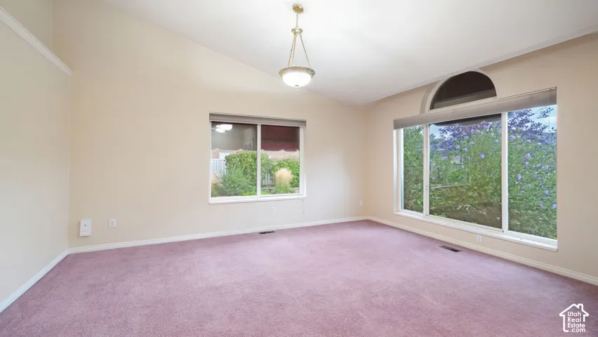 Vaulted ceiling featuring a central pendant light, expansive windows, and a semi-circular arched window transom