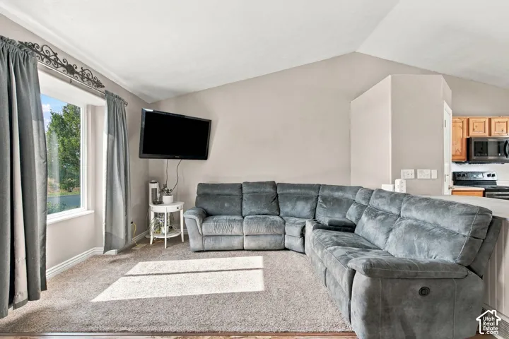 Vaulted ceilings, large bay window, and neutral wall tones