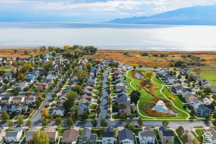 Aerial perspective featuring open green spaces, pedestrian pathways, dual retention ponds, and a mountain backdrop