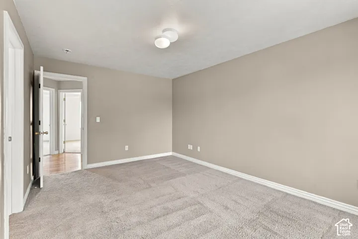 Neutral-toned interior room featuring wall-to-wall carpeting and a dual-globe ceiling light fixture