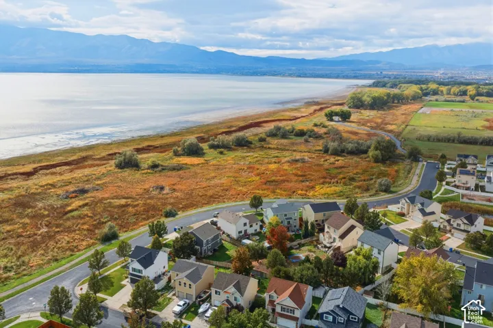 Aerial perspective featuring expansive shoreline terrain, prominent mountain backdrop, and proximity to open water
