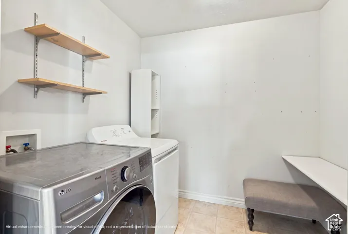 Dedicated laundry room featuring wall-mounted open shelving, a recessed plumbing connection box, a white vertical storage unit, and tile flooring