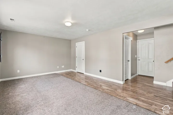 Neutral-toned walls, wood-finish flooring, wall-to-wall carpeting, and six-panel interior doors