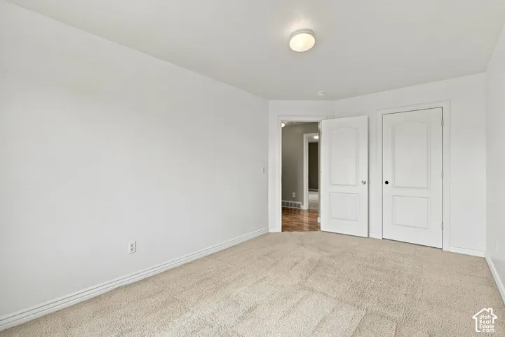 Neutral-toned wall-to-wall carpeting, two-panel interior doors, and a central flush-mount ceiling light fixture